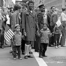 Black family marching together with American flags