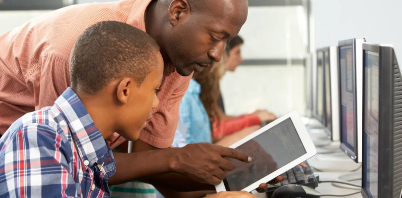 Mentor guiding a student at computer